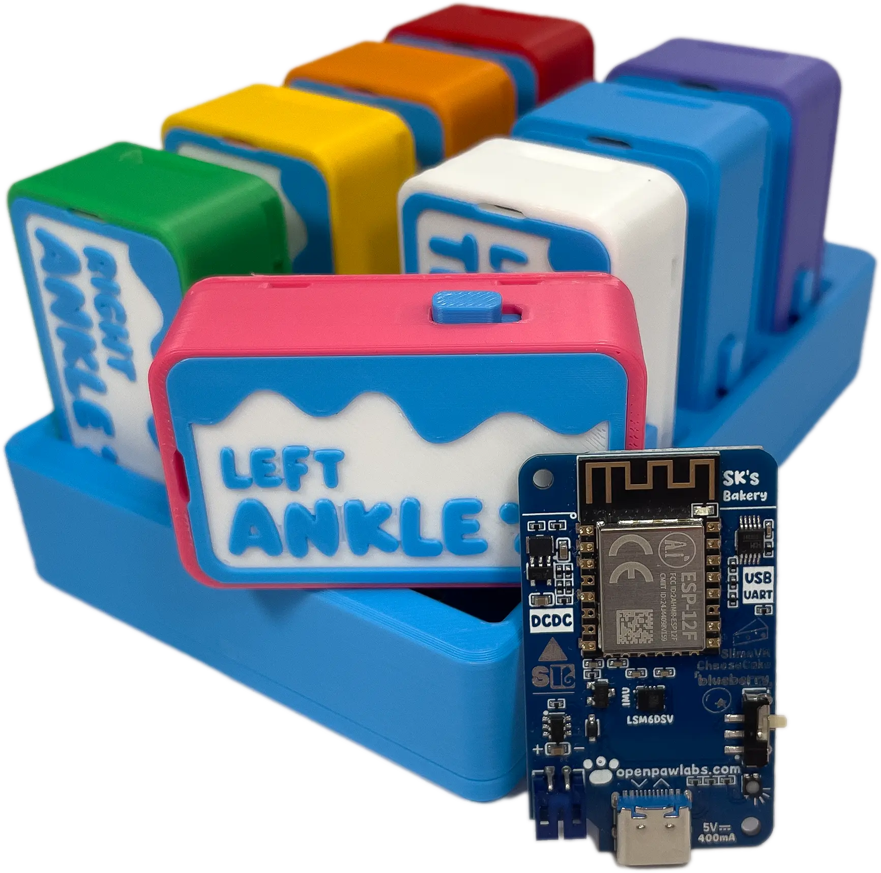 Bare tracker board standing in front of a full set of colorful assembled trackers on their charging dock